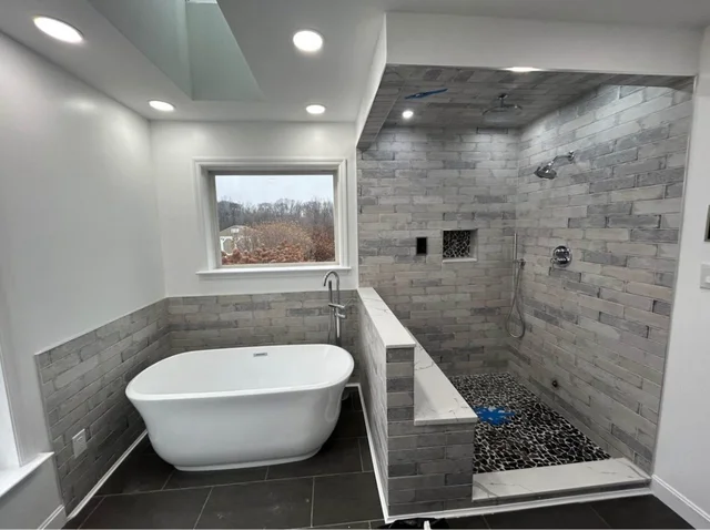 Freestanding bathtub beside a tiled walk-in shower