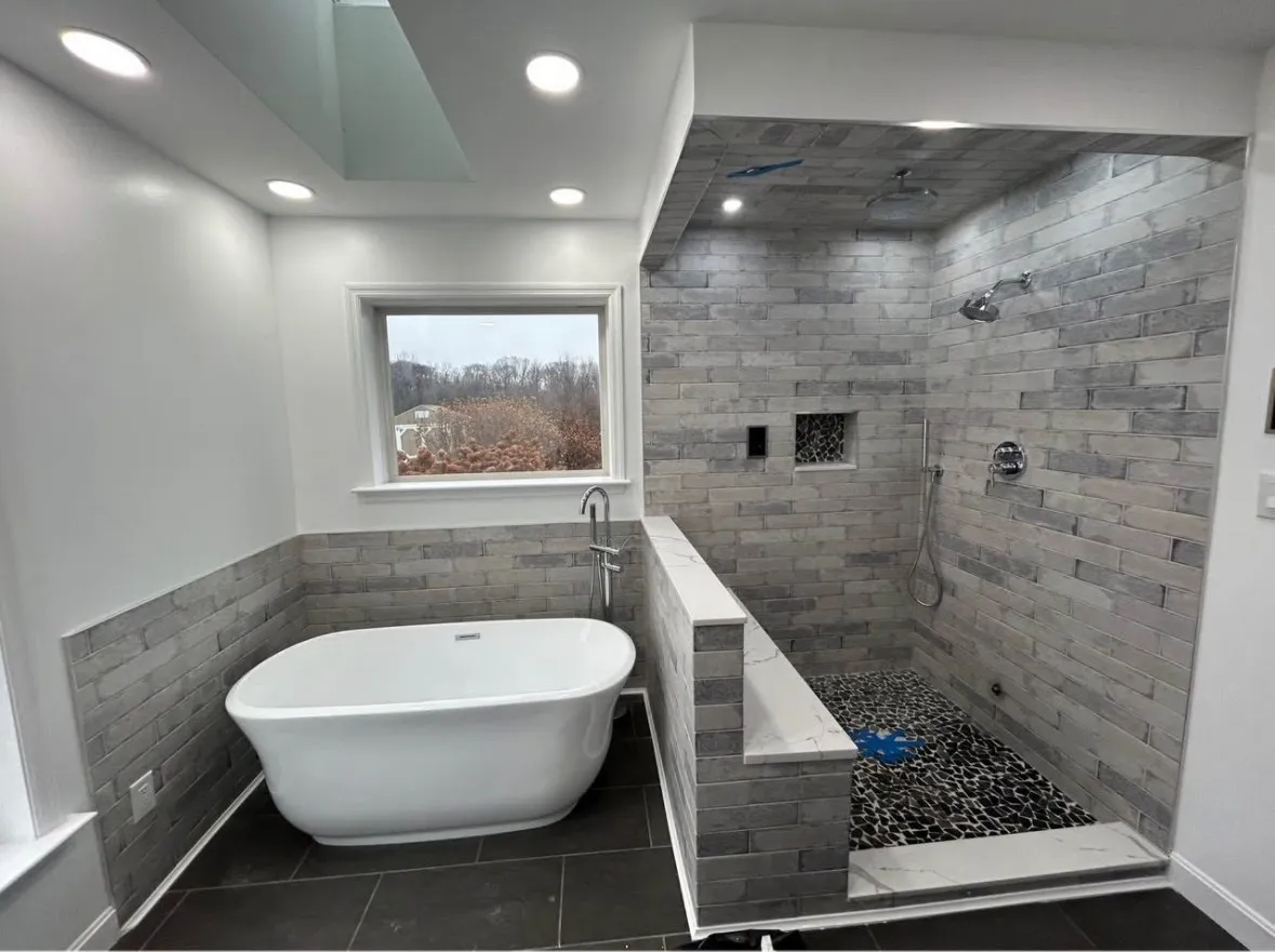 Bathroom with a tub and tiled shower