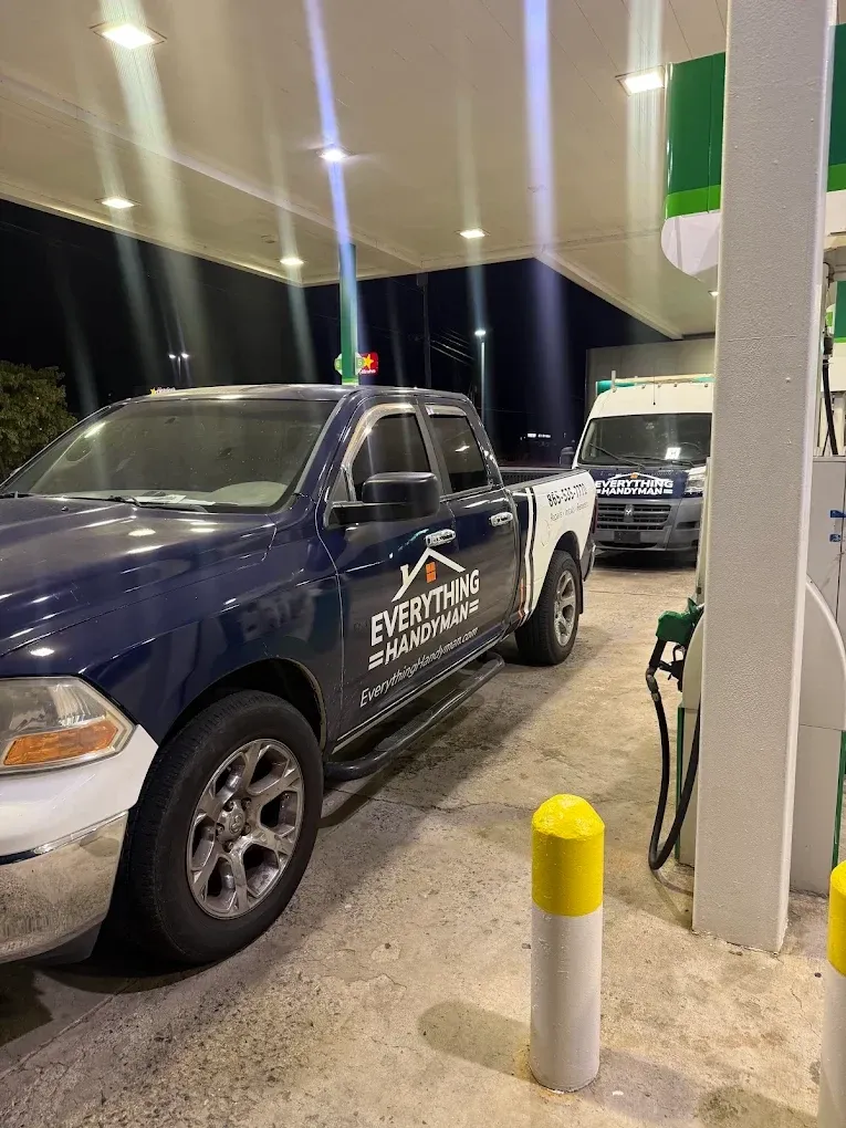 Everything Handyman branded pickup and van parked at a fuel station at night