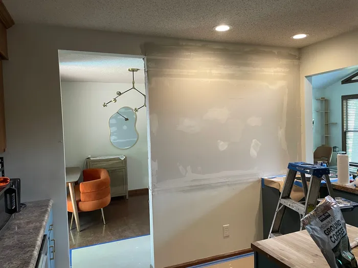 Room walls with visible drywall patches and joint compound