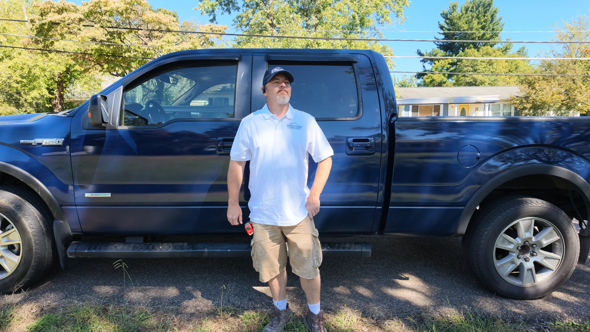 Everything Handyman team member in a branded polo and cap beside our blue work truck