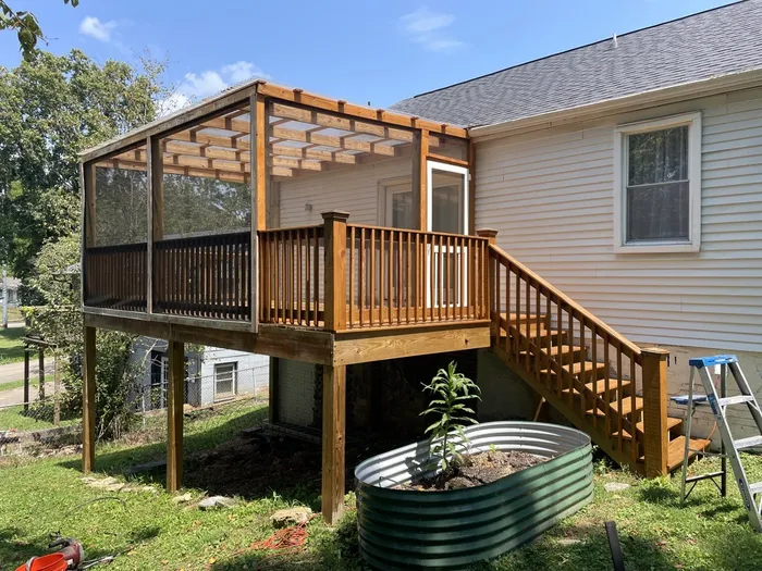 Raised timber deck, steps and screened porch beside a home
