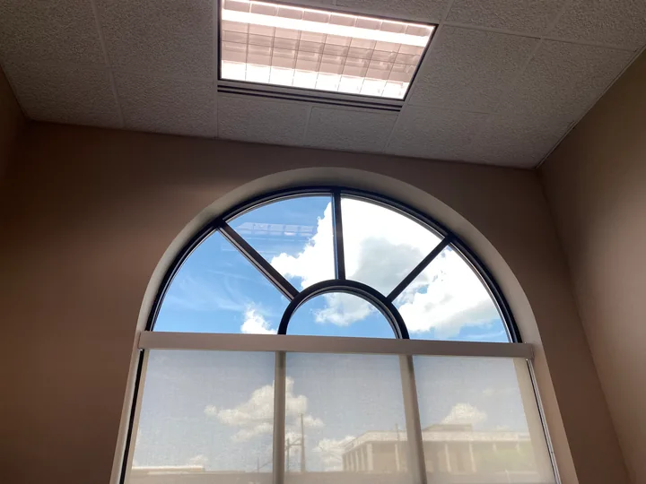 Large arched window and nearby skylight in an interior room