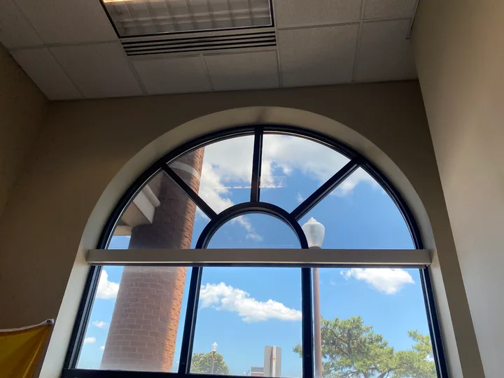 Large arched window and nearby skylight in an interior room