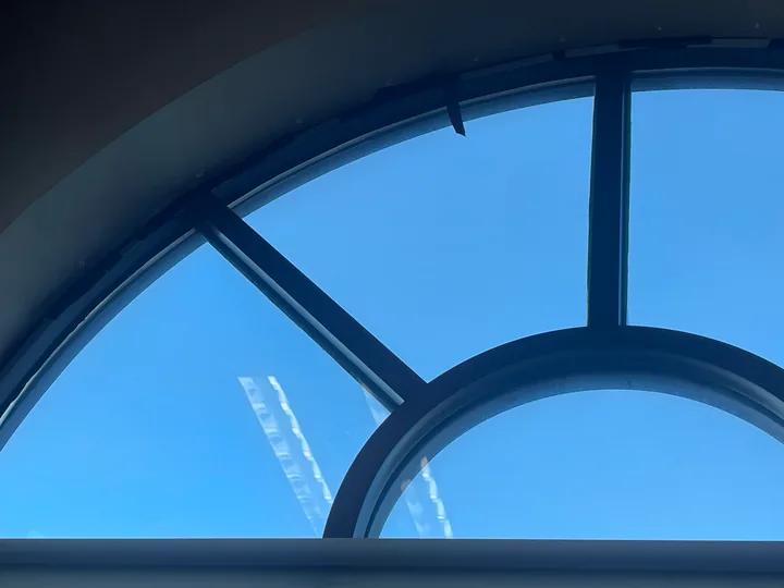 Large arched window and nearby skylight in an interior room