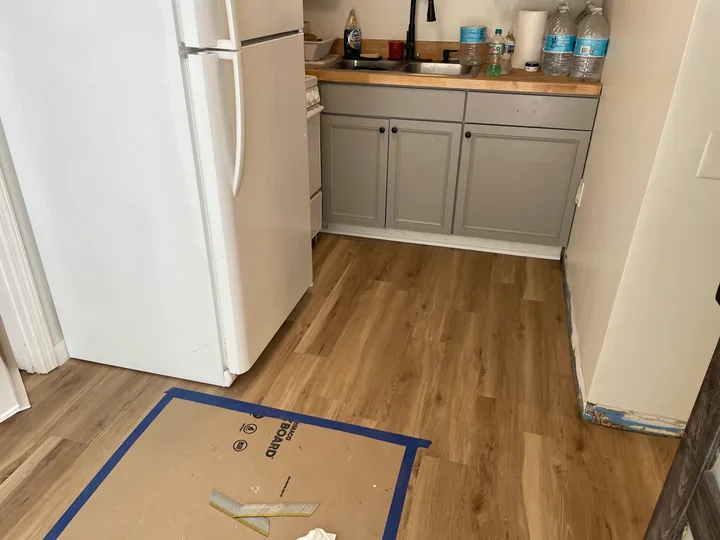 Wood-look plank flooring beside a toilet and white bathroom vanity