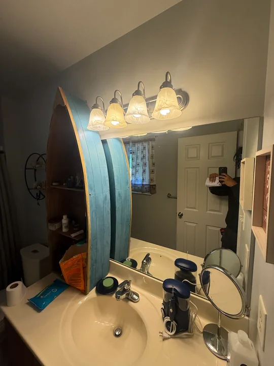 Bathroom with green upper walls, tub surround, vanity and patterned plank flooring