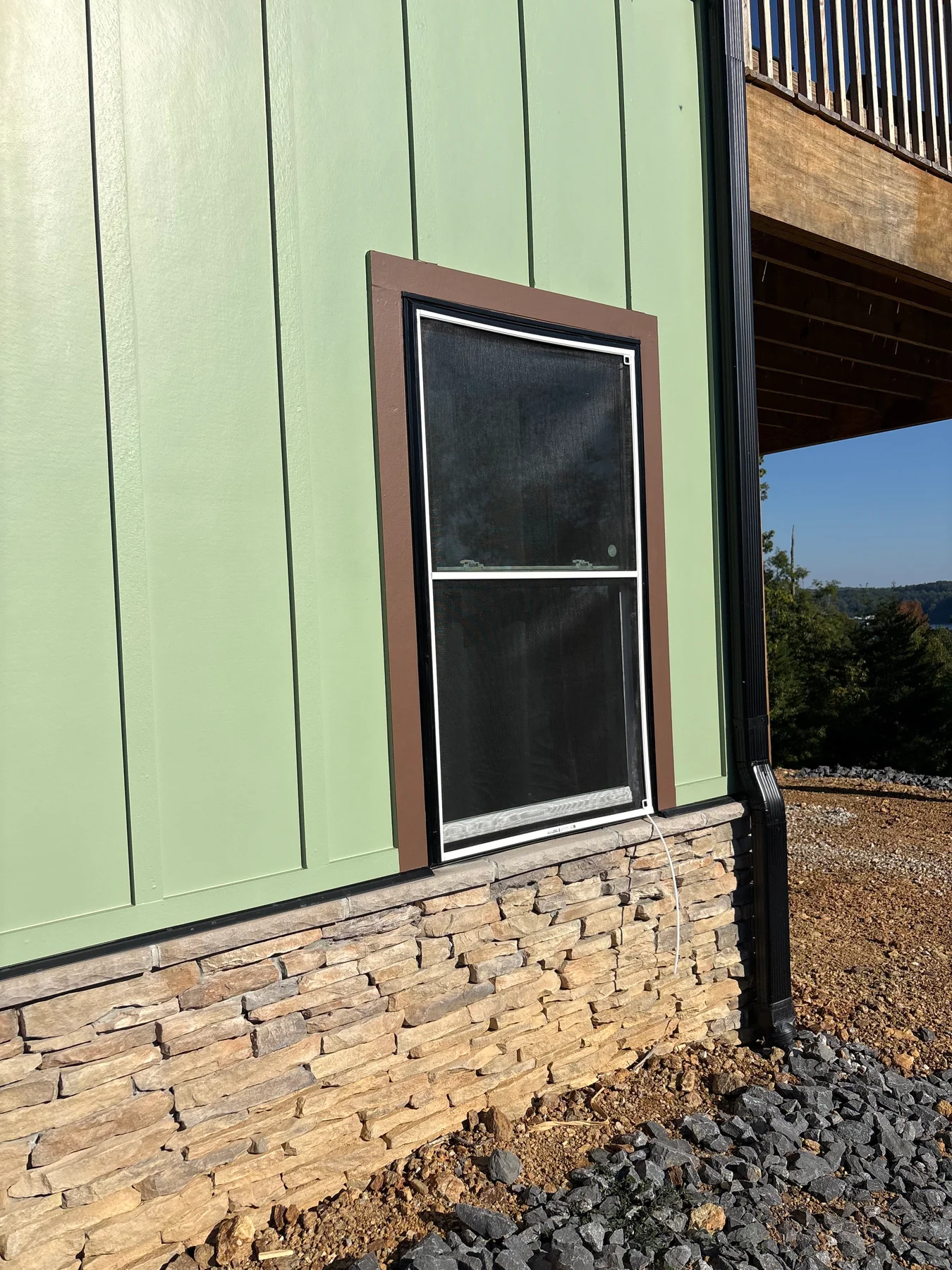 Green board-and-batten siding, windows and exterior wood trim