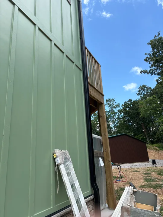 Green board-and-batten siding, windows and exterior wood trim