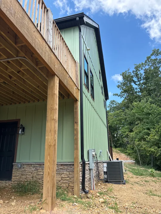 Green board-and-batten siding, windows and exterior wood trim