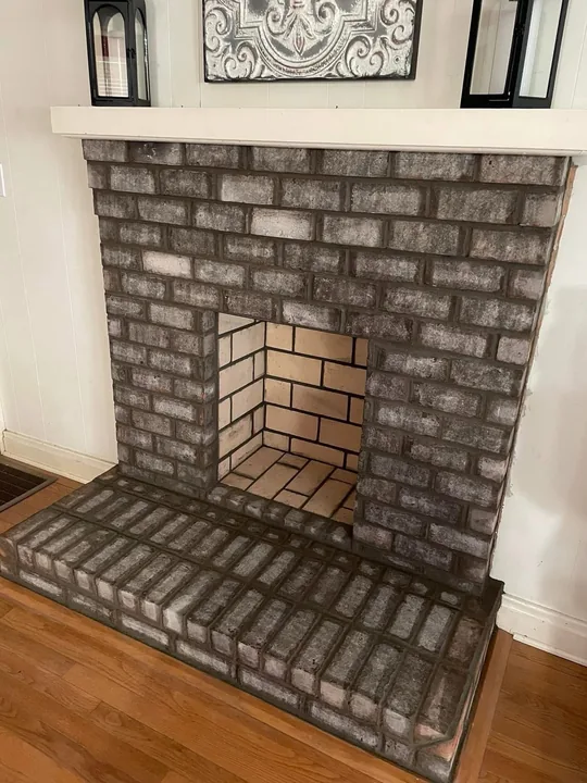 Brick fireplace opening and light mantel surround