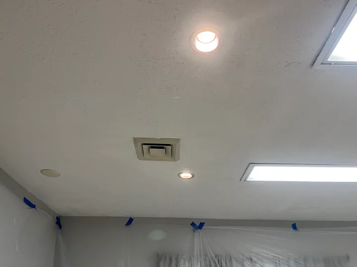 Room windows, ceiling lights and surfaces being prepared for finishing