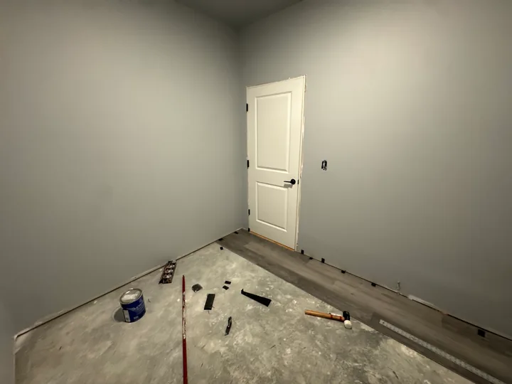 Plank flooring in a closet with white storage rails and shelving