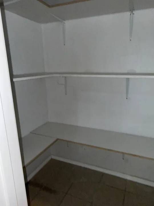 Built-in white closet shelving and bench surfaces