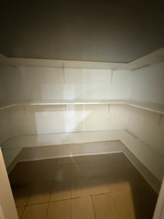 Built-in white closet shelving and bench surfaces