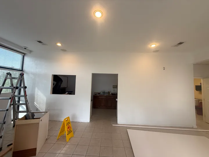 Painted commercial partition with two doorways and a service opening