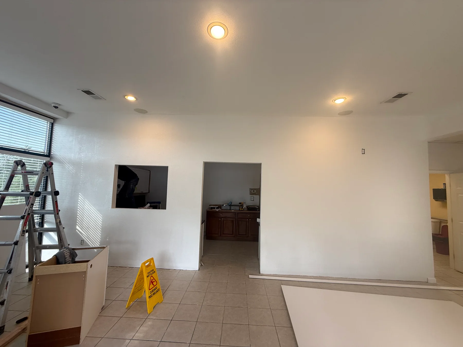 Painted commercial partition with two doorways and a service opening
