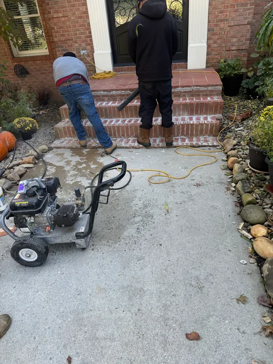 Exterior concrete and masonry steps beside a brick entrance