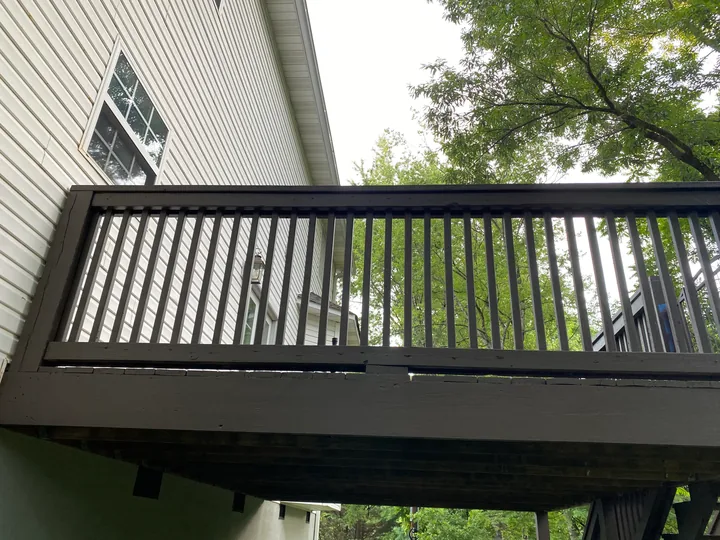 Dark deck railing and perimeter trim beside a home