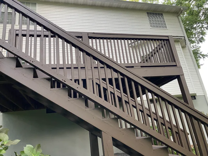 Dark deck railing and perimeter trim beside a home