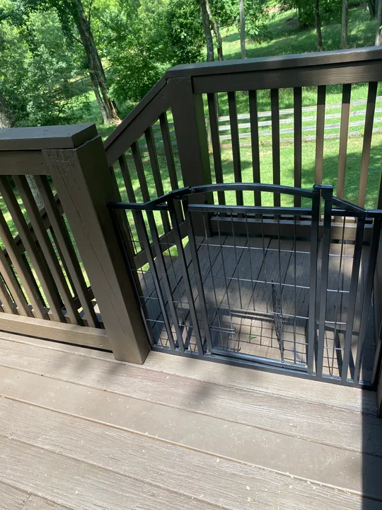 Dark deck railing and perimeter trim beside a home