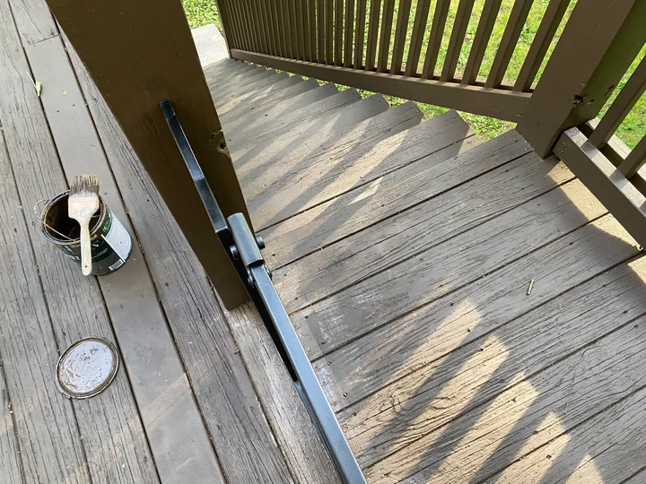Dark deck railing and perimeter trim beside a home