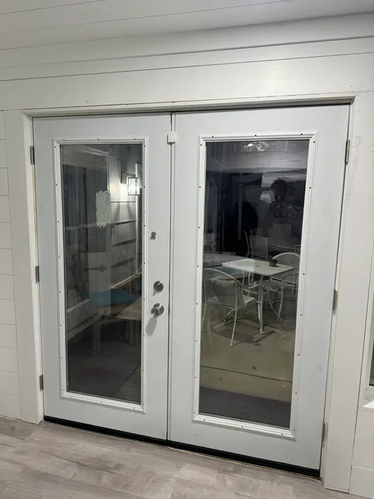 White double glass doors beside a room undergoing renovation