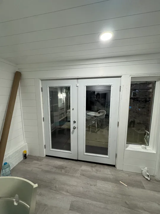 White double glass doors beside a room undergoing renovation
