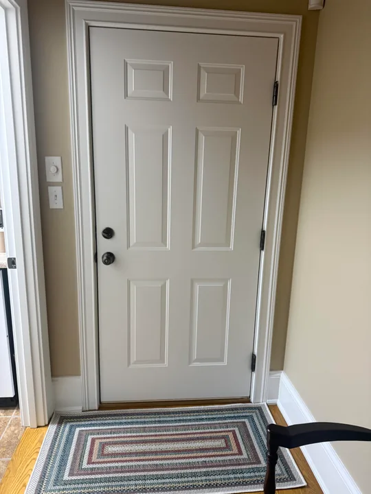 White entry door, threshold and stone exterior wall