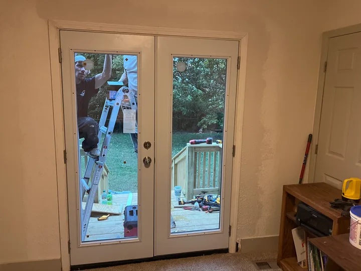 Timber entry steps and double exterior doors beside a home
