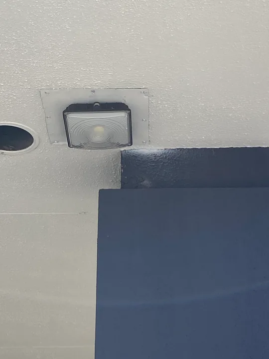 Square exterior wall light beside a soffit