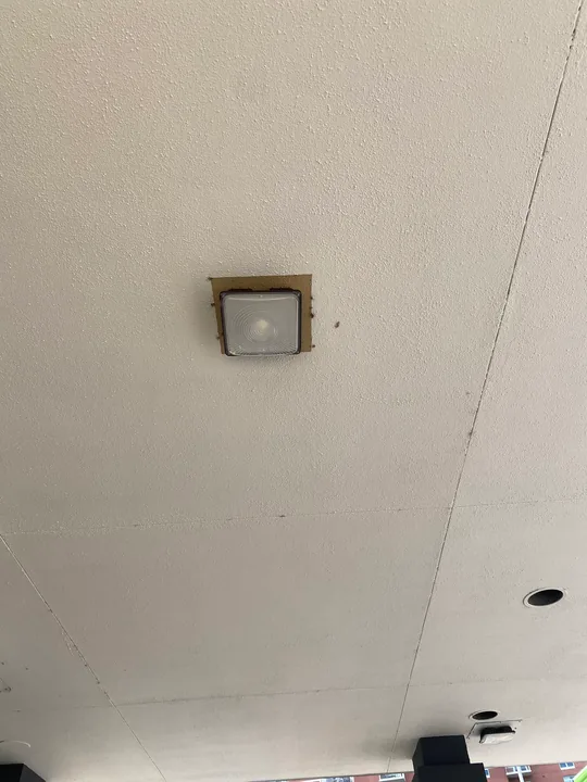 Square exterior wall light beside a soffit