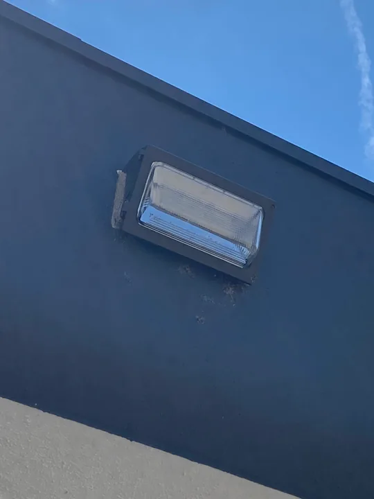 Square exterior wall light beside a soffit
