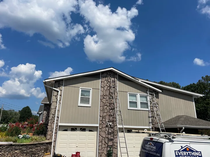 Home exterior with siding, stone facade and white window trim