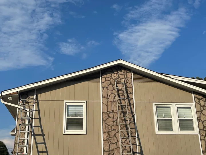 Home exterior with siding, stone facade and white window trim