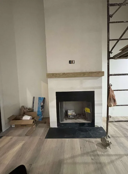 Fireplace insert and wood mantel in a light wall