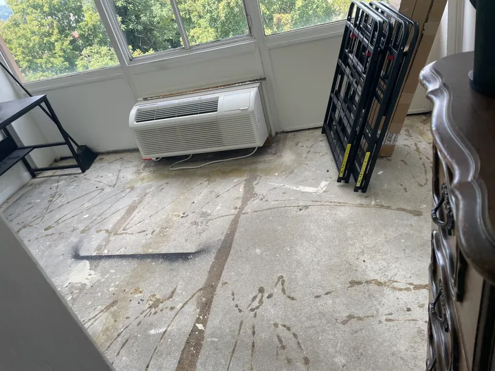 Room floor with old covering removed and surface preparation visible