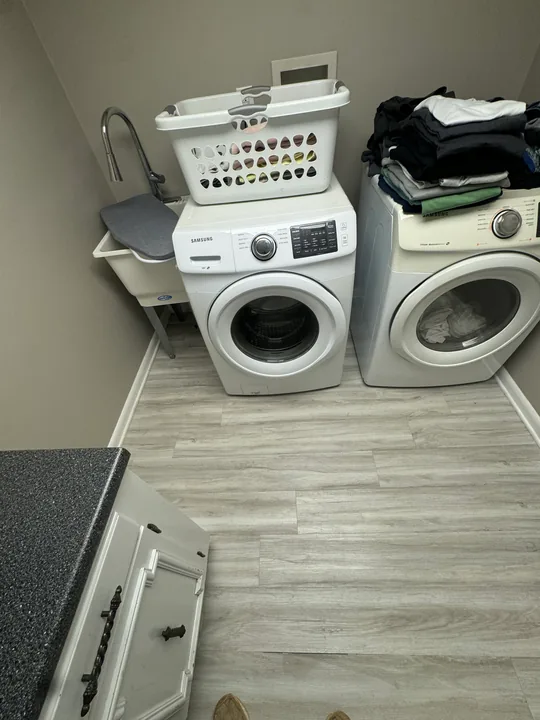 Gray plank flooring and installation work beside a bathroom vanity