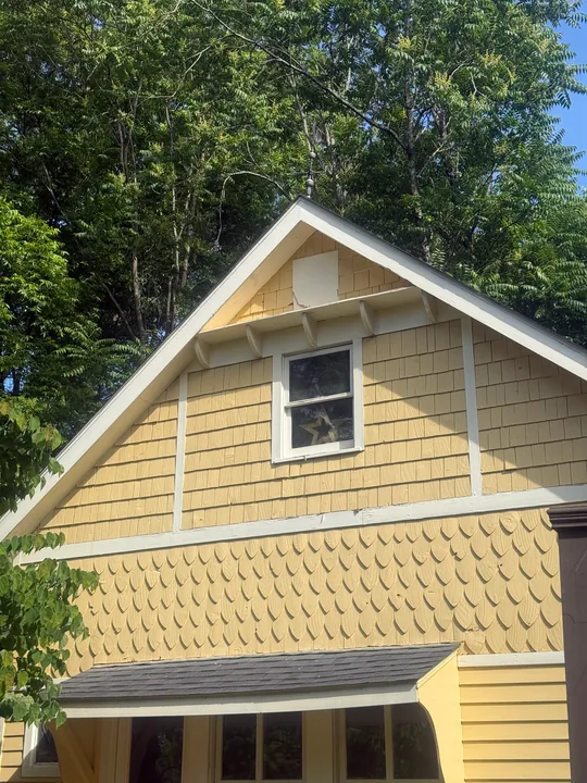 Light siding and white trim on a house gable