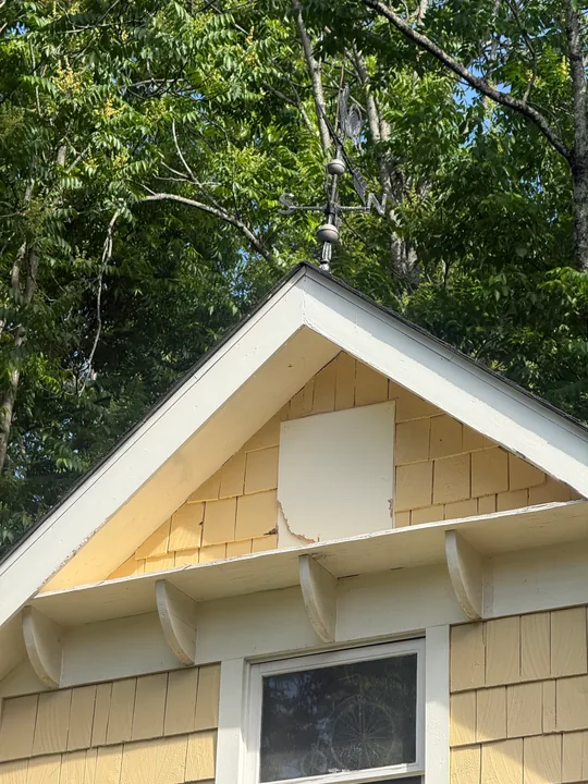 Light siding and white trim on a house gable