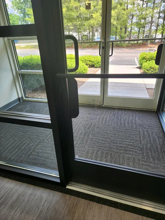 Dark-framed glass commercial entrance and door hardware
