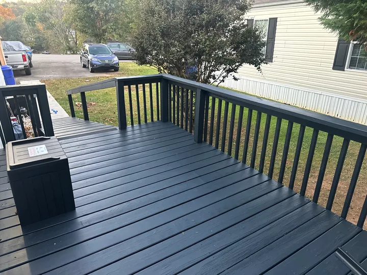 Gray deck, dark railings and a long access ramp beside a home