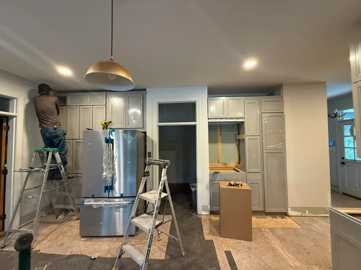 Crew working on the gray kitchen during the remodel