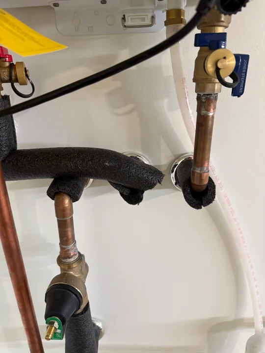 Water heater and accessible utility connections beside an open wall