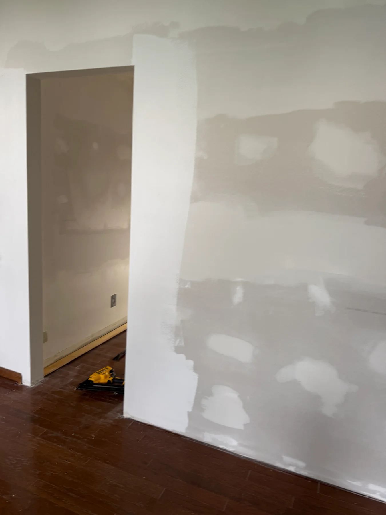 Drywall seams and patched fasteners around an interior doorway