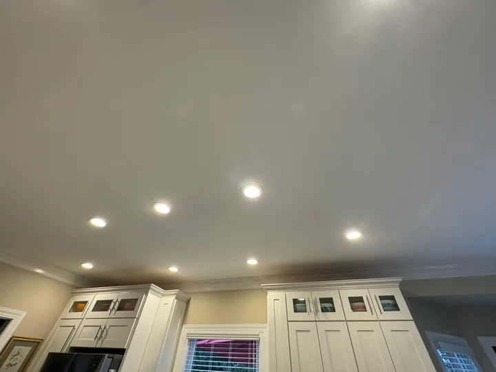 Light kitchen ceiling with recessed lights and white cabinets