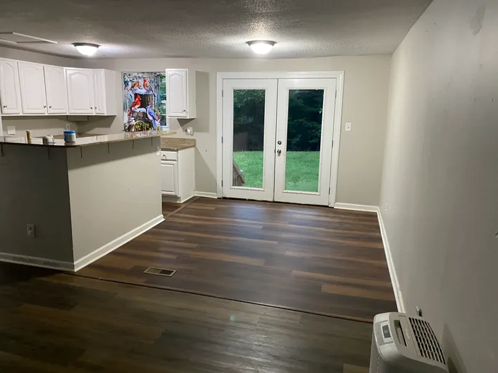 Dark plank flooring through an open living room and kitchen