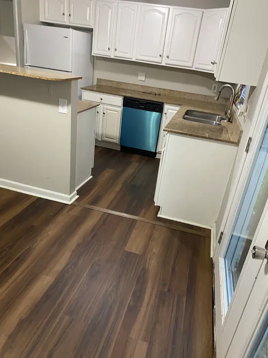 Dark plank flooring through an open living room and kitchen