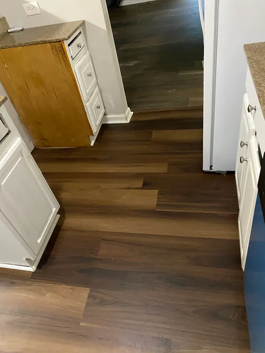 Dark plank flooring through an open living room and kitchen