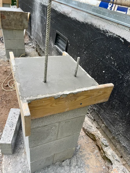 Masonry support piers and concrete formwork beside a home